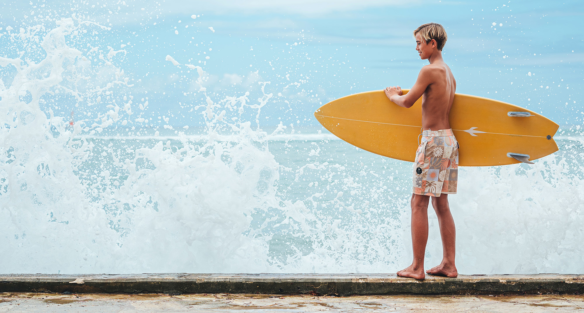 Boy holding surfboard