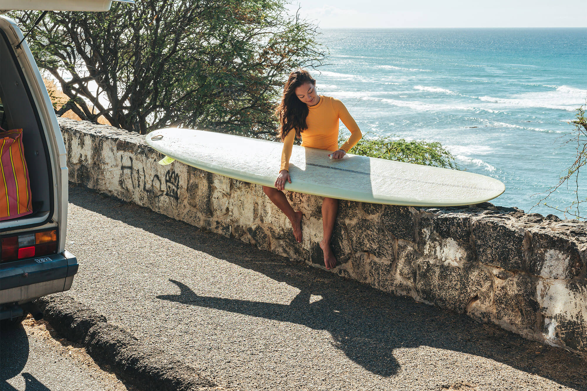 Woman waxing a Surfboard